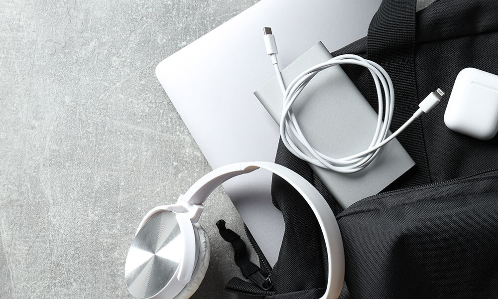 Technisches Equipment für neue Mitarbeitende bei The Quality Group wie Laptop, Kopfhörer und Zubehör